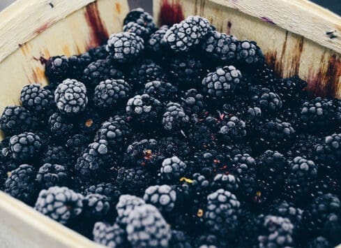 Fresh blackberries in wooden basket, ripe and ready to eat
