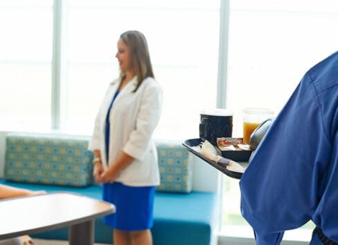 Businesswoman carrying food tray in office cafeteria