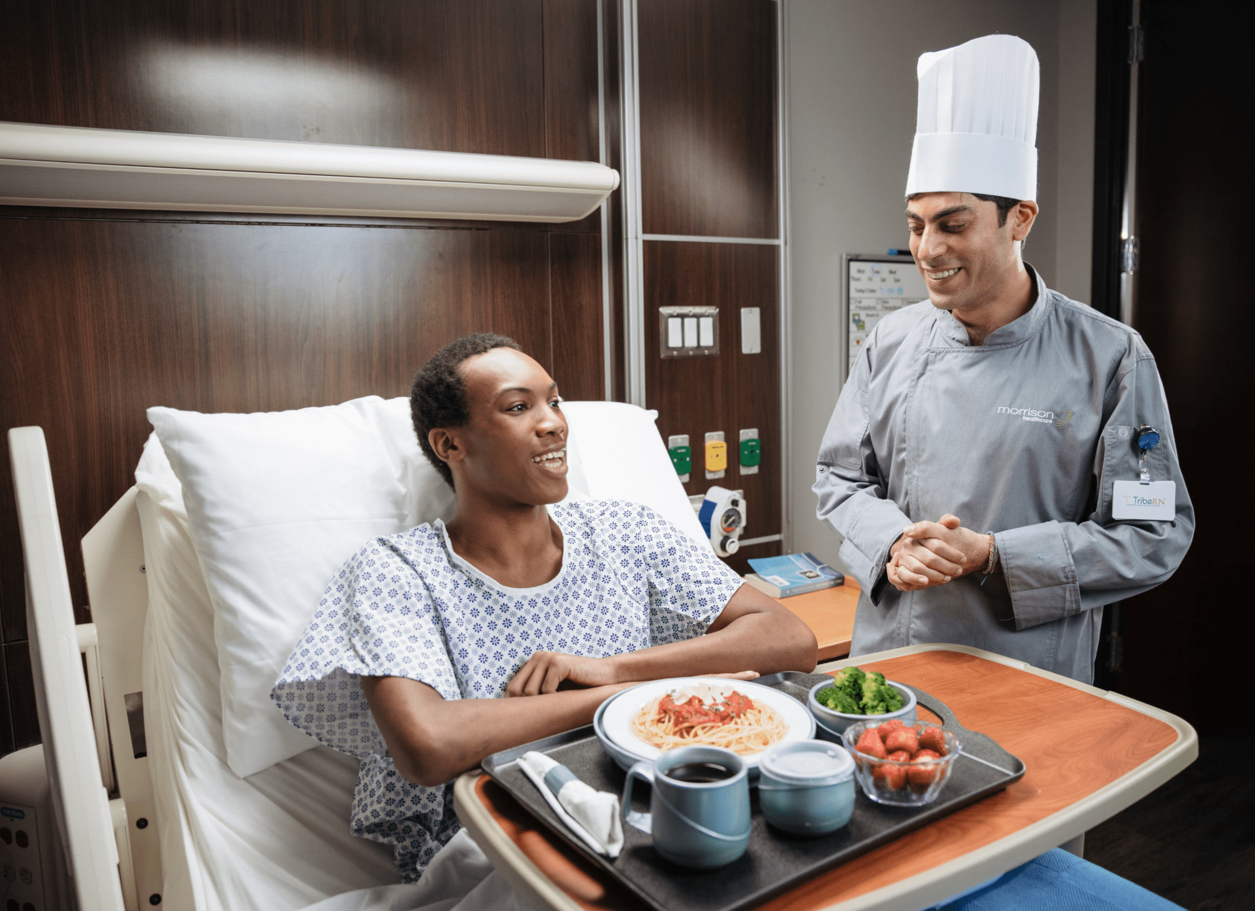 Man sitting in a hospital bed with a chef