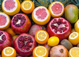 Fresh citrus fruits and pomegranates with vibrant colors, whole and sliced