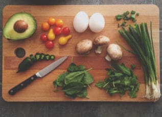 Fresh vegetables, eggs, and mushrooms on a cutting board, ingredients for a healthy meal