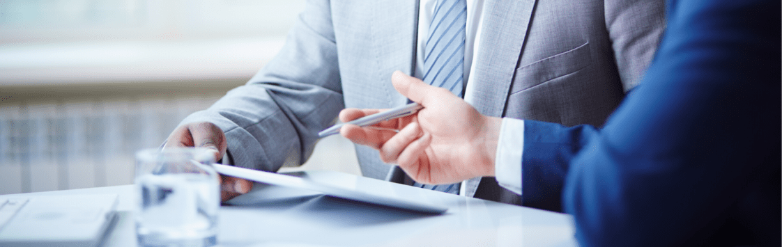 Business executives reviewing paperwork together at conference table