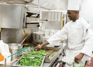 Chef preparing fresh greens in commercial kitchen for Morrison Healthcare food service