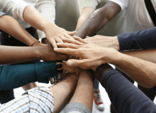 Healthcare team joining hands in unity and teamwork