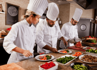 Chefs preparing healthy meals with fresh vegetables in a professional kitchen at Morrison Healthcare.