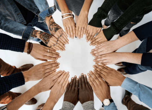 Group of diverse hands together in circle showing unity and teamwork