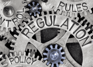 Rules, regulation, policy text engraved in gears, representing legal or regulatory controls
