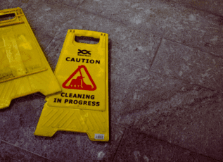 Caution sign indicating cleaning in progress on tiled floor