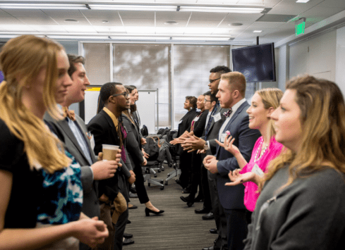 Business team meeting discussing work in office hallway