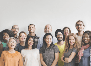 Diverse group of smiling people standing together against plain background
