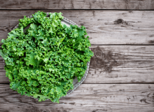 Fresh curly green kale on rustic wooden table