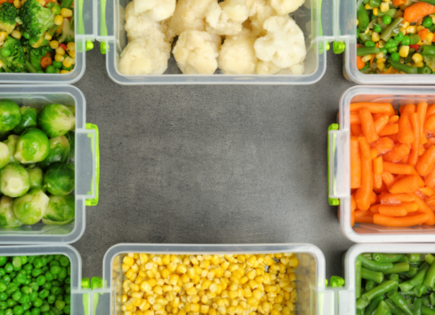Vegetable meal prep containers with carrots, brussels sprouts, peas, cauliflower and corn