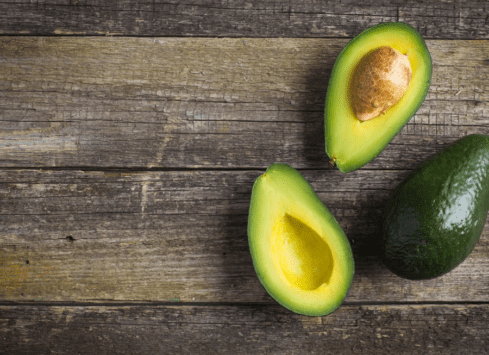 Ripe avocado halves on rustic wooden table, healthy green superfood ingredient for nutritious diet