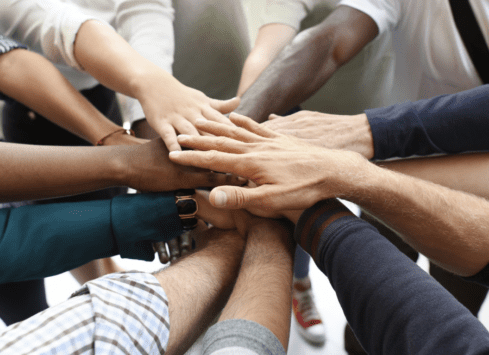 Diverse group of hands stacked together, showing teamwork and unity
