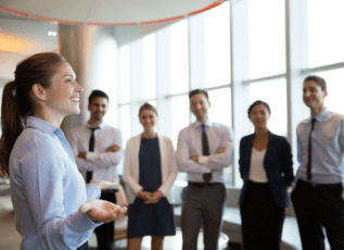 Business team members smiling and standing together in modern office conference room
