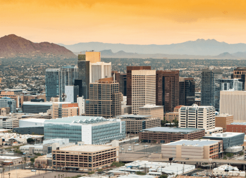 Phoenix skyline with high-rise buildings and mountains at sunset