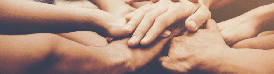 Diverse hands joined together in teamwork and collaboration