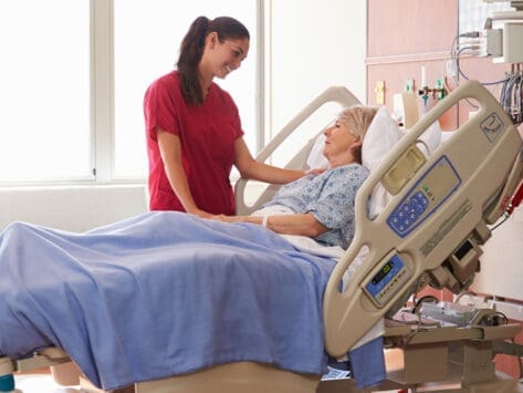 Nurse assisting patient in hospital bed, providing care and comfort