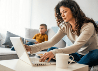 Woman and boy using laptop and tablet while sitting on couch