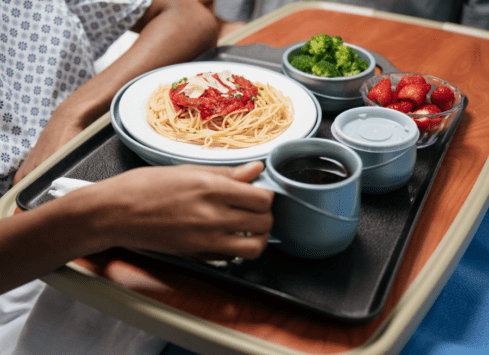 Patient meal tray with spaghetti, broccoli, and strawberries served in healthcare setting