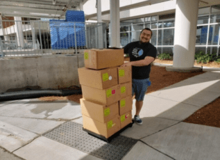 Morrison employee delivering packaged meals outside office building