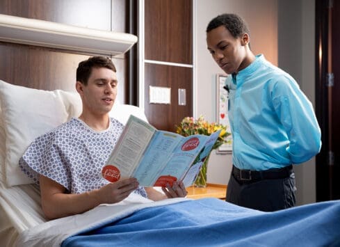 Patient and nurse reviewing educational materials while in hospital room