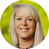 Smiling blonde woman with green background, Morrison Healthcare staff headshot