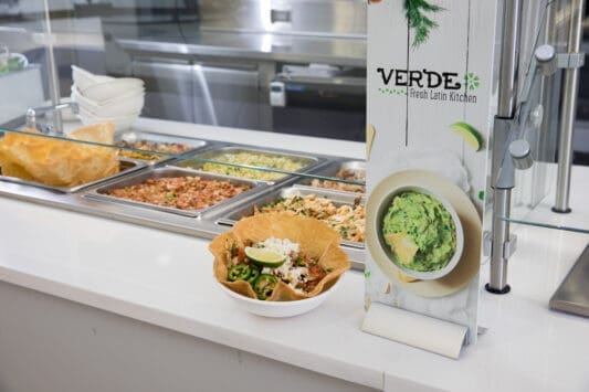 Verde Fresh Latin Kitchen serving line with burritos, rice and guacamole in modern cafeteria setting