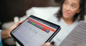 Woman viewing nutrition information on digital tablet in hospital bed
