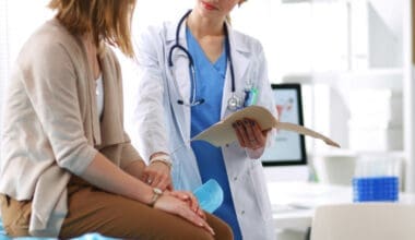 Doctor assisting patient in medical office with digital tablet