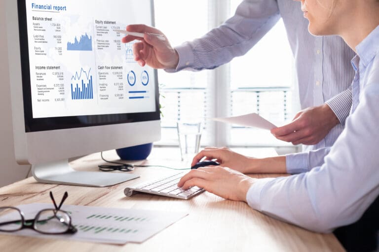 Analyzing financial report data on computer screen in office