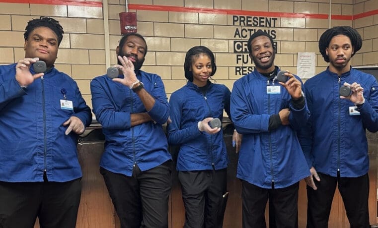 Diverse group of cheerful hospital food service workers holding meal replacement drinks