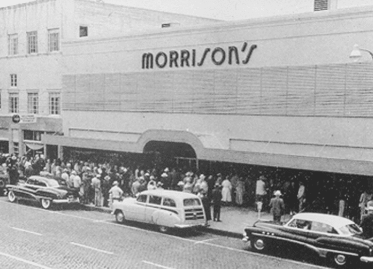 Morrison's department store exterior with crowd gathered, 1950s cars parked out front