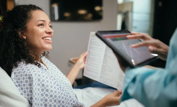 Smiling patient holding medical chart during consultation with doctor