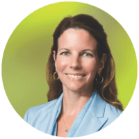 Smiling businesswoman wearing blue blazer on green background, leadership headshot