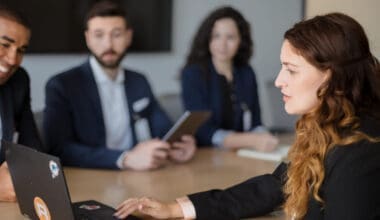 Businesswoman typing on laptop during meeting with diverse colleagues