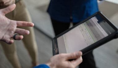 Hands holding tablet showing healthcare information, promoting Morrison Healthcare's services