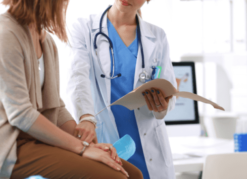 Doctor and patient reviewing medical records on tablet in office