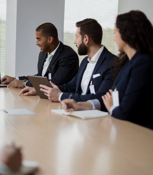 Morrison Healthcare team in a conference room reviewing financial data on a laptop during a meeting.