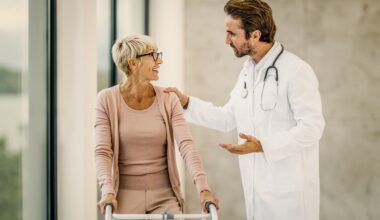 Morrison Healthcare clinician in a white coat speaks with a smiling older adult in a bright medical facility hallway.